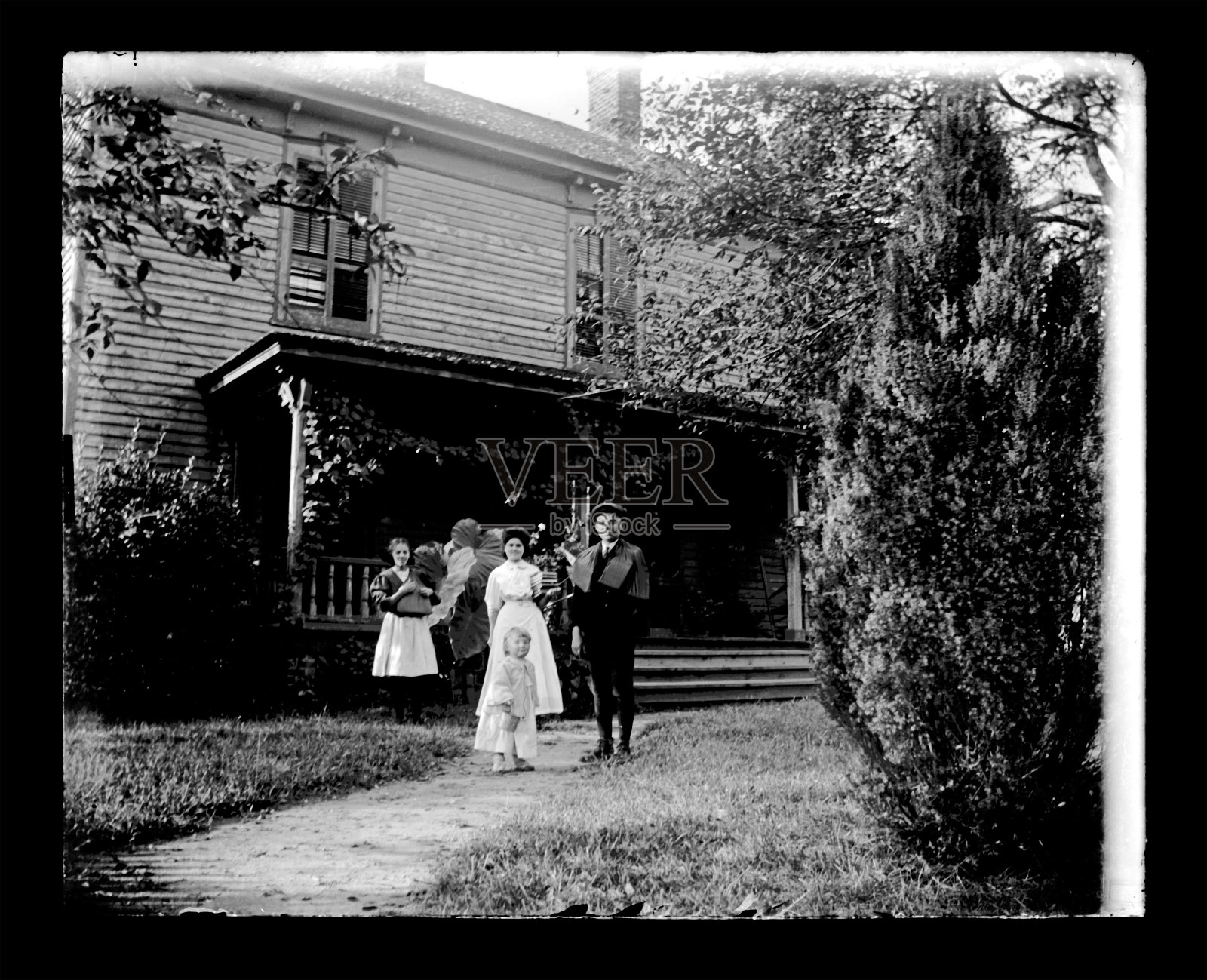 农舍前的一家人，大约1890年照片摄影图片