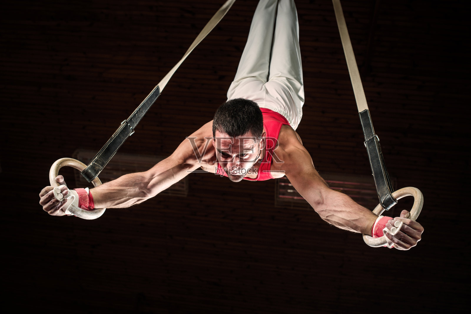 男子运动员在体操吊环上。照片摄影图片