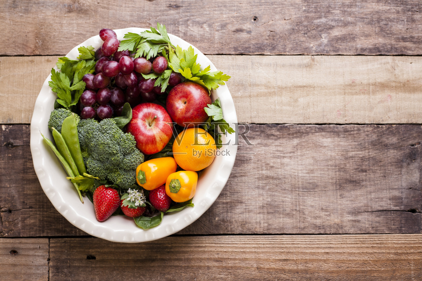 质朴的木桌上摆放着五颜六色的有机水果、蔬菜。照片摄影图片