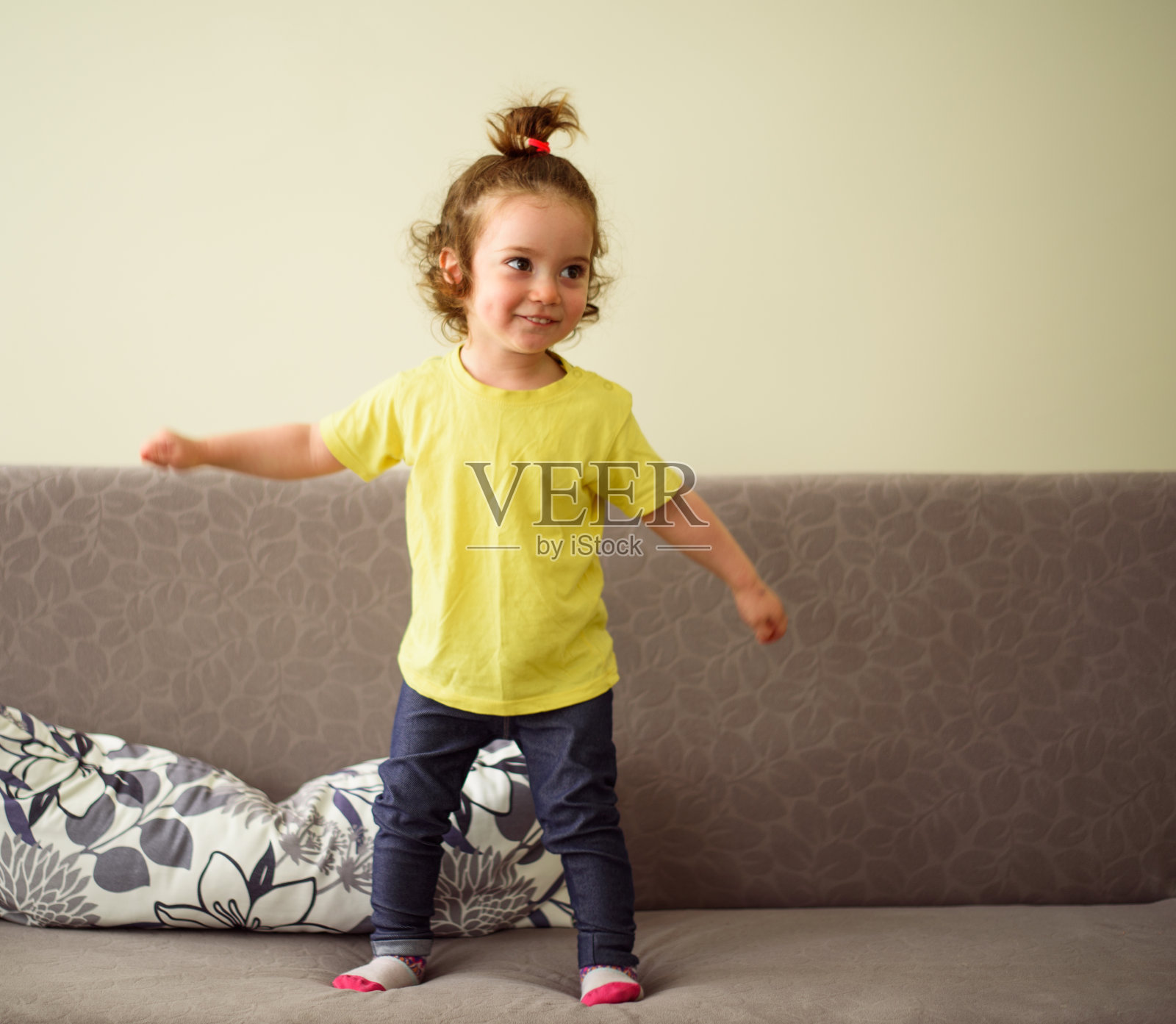 快乐的宝贝女孩在沙发上跳舞照片摄影图片