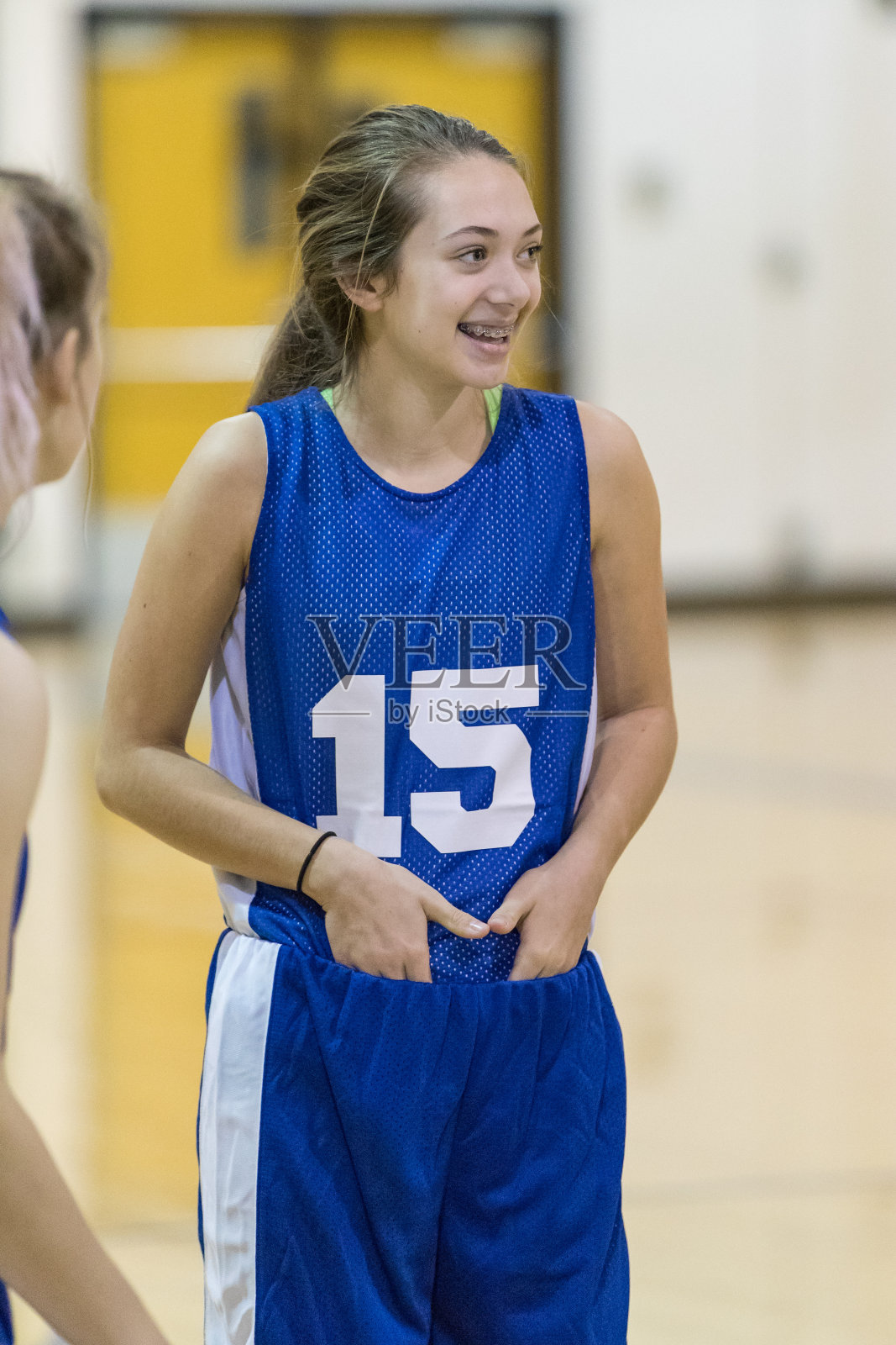 女孩高中篮球运动员在比赛前塞好球衣照片摄影图片