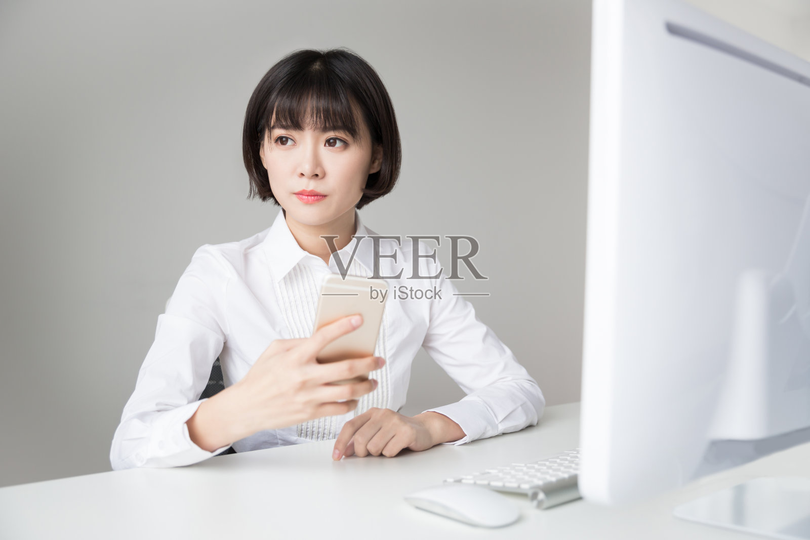 中国漂亮女孩在办公室用手机照片摄影图片