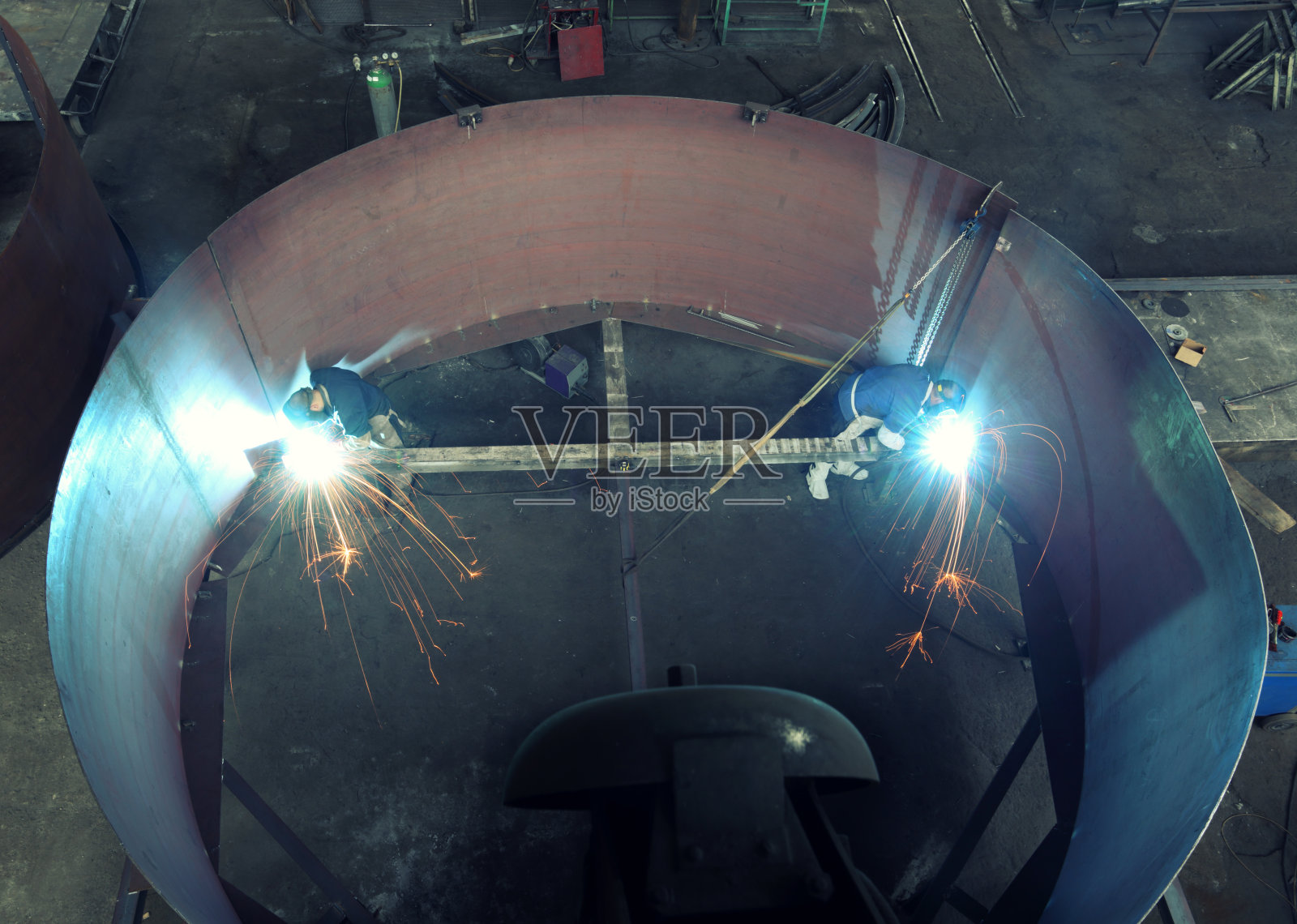两个焊工在一个巨大的金属圆筒里工作照片摄影图片