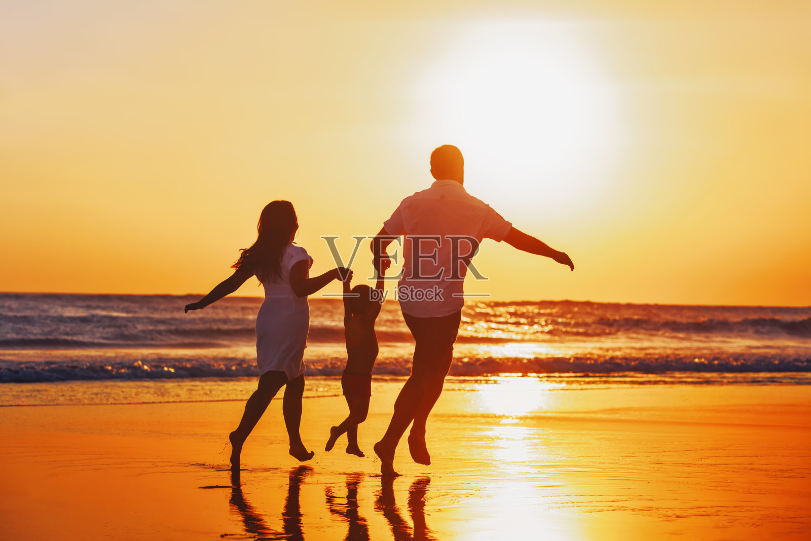 幸福的家庭和孩子有一个有趣的日落海滩照片摄影图片