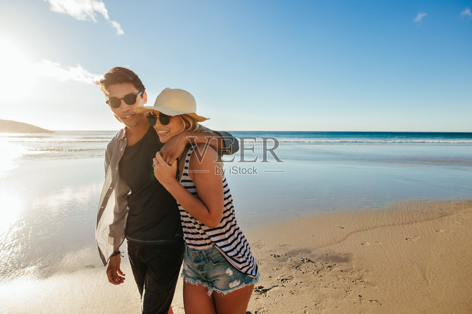 一对幸福的情侣在海滩上散步照片摄影图片