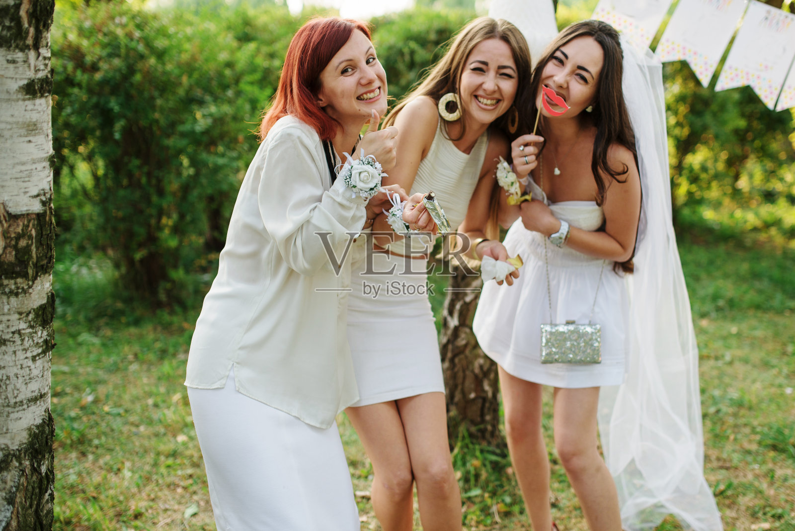 女孩们穿着白色的裙子在女性聚会上玩。照片摄影图片