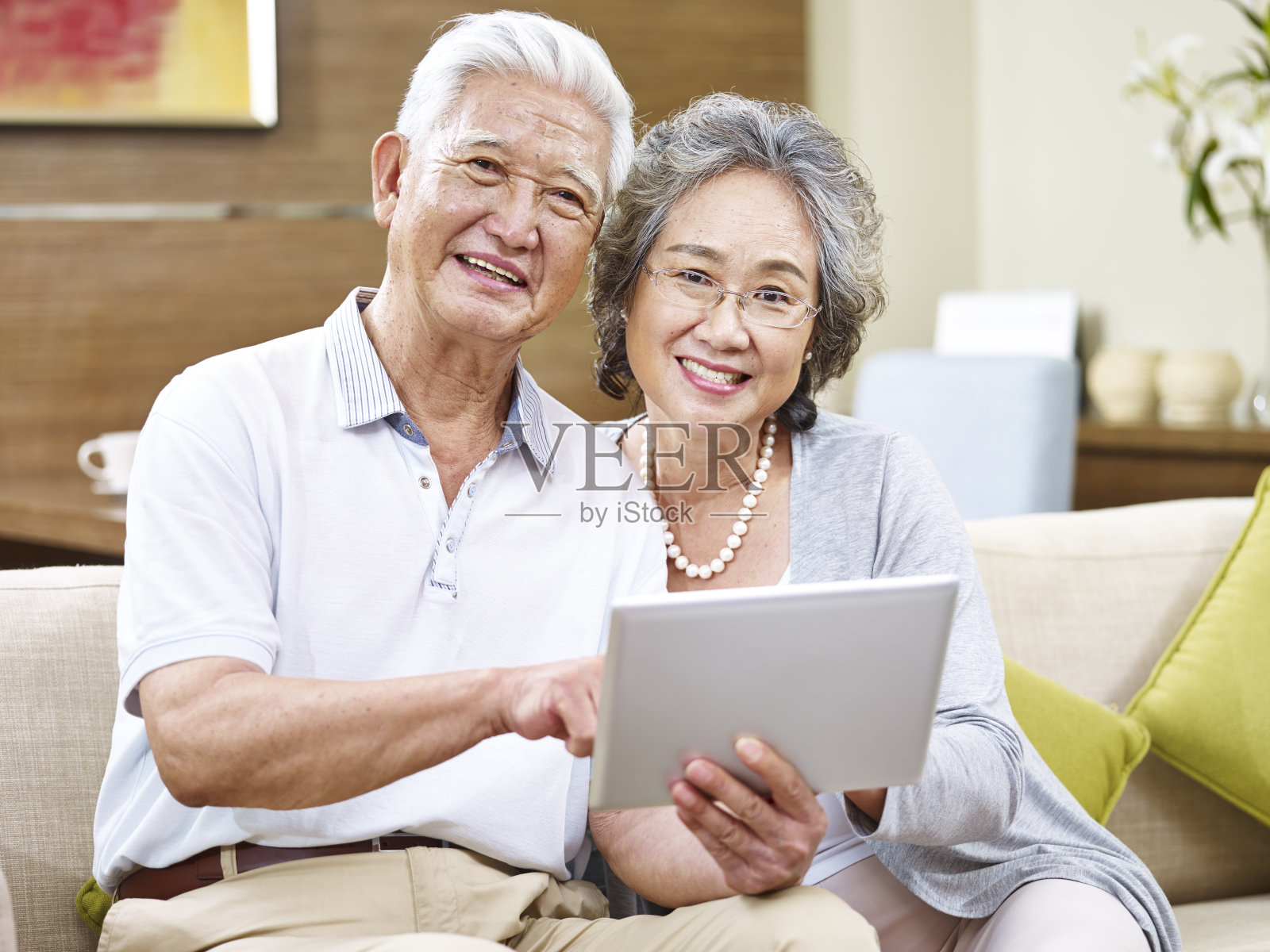 快乐的资深亚洲夫妇使用数字平板电脑照片摄影图片