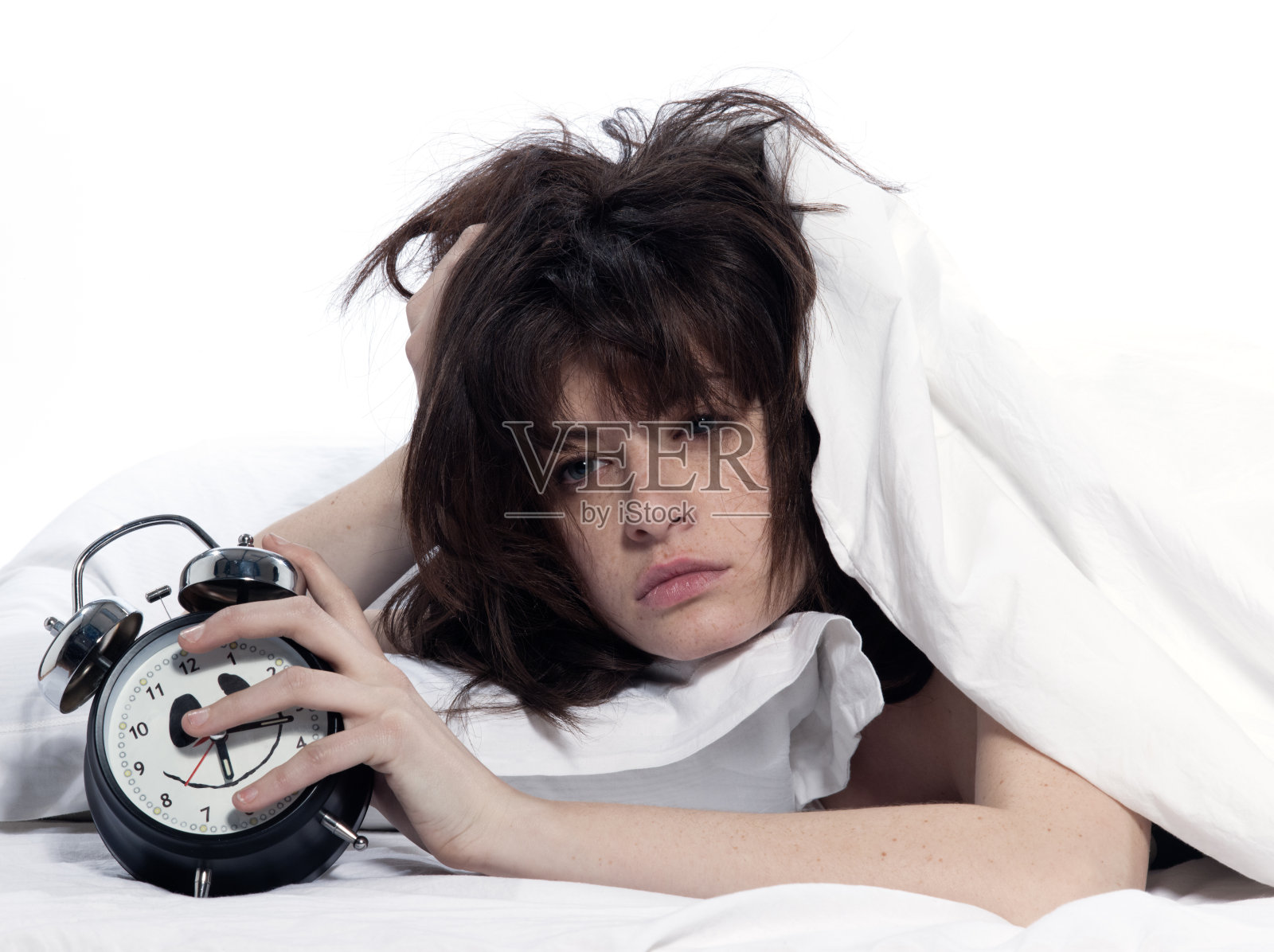 女人在床上醒来，累了，抱着闹钟照片摄影图片