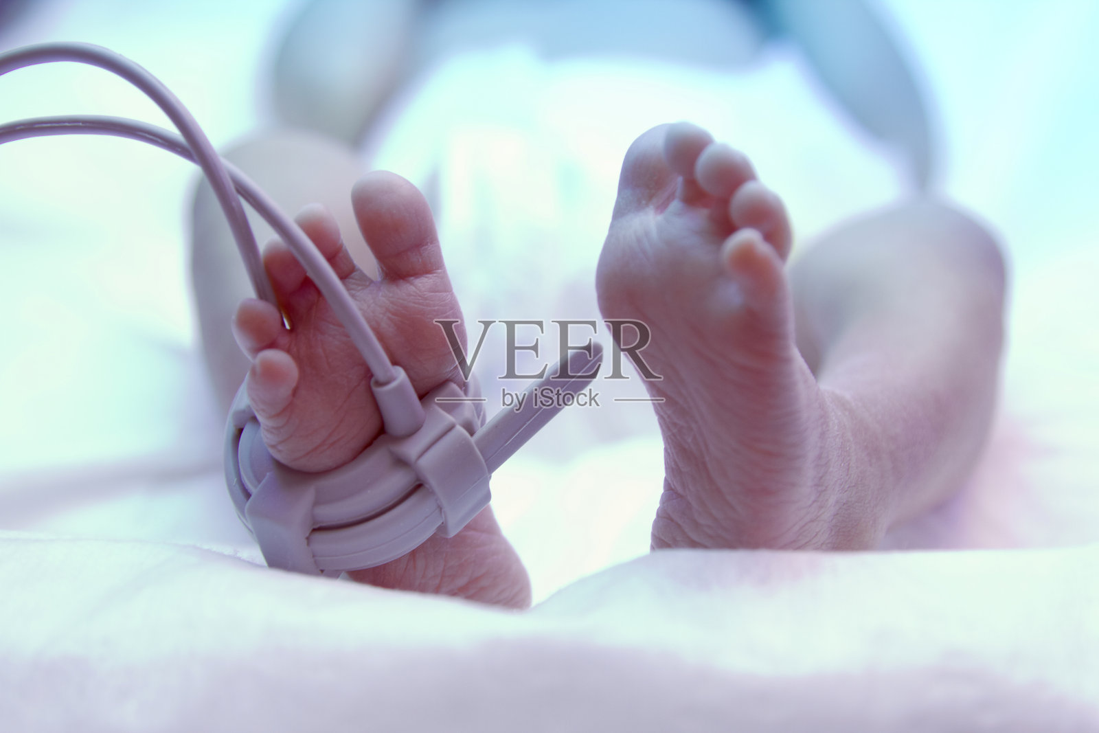 紫外线灯下新生儿的脚照片摄影图片