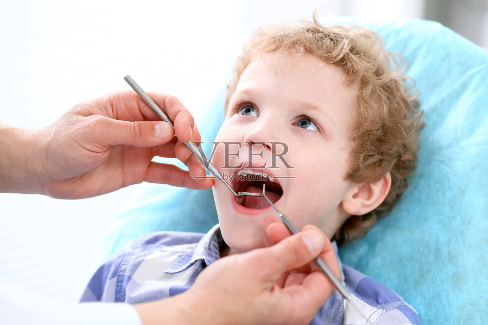 男孩有他的牙齿检查由牙医的特写照片摄影图片