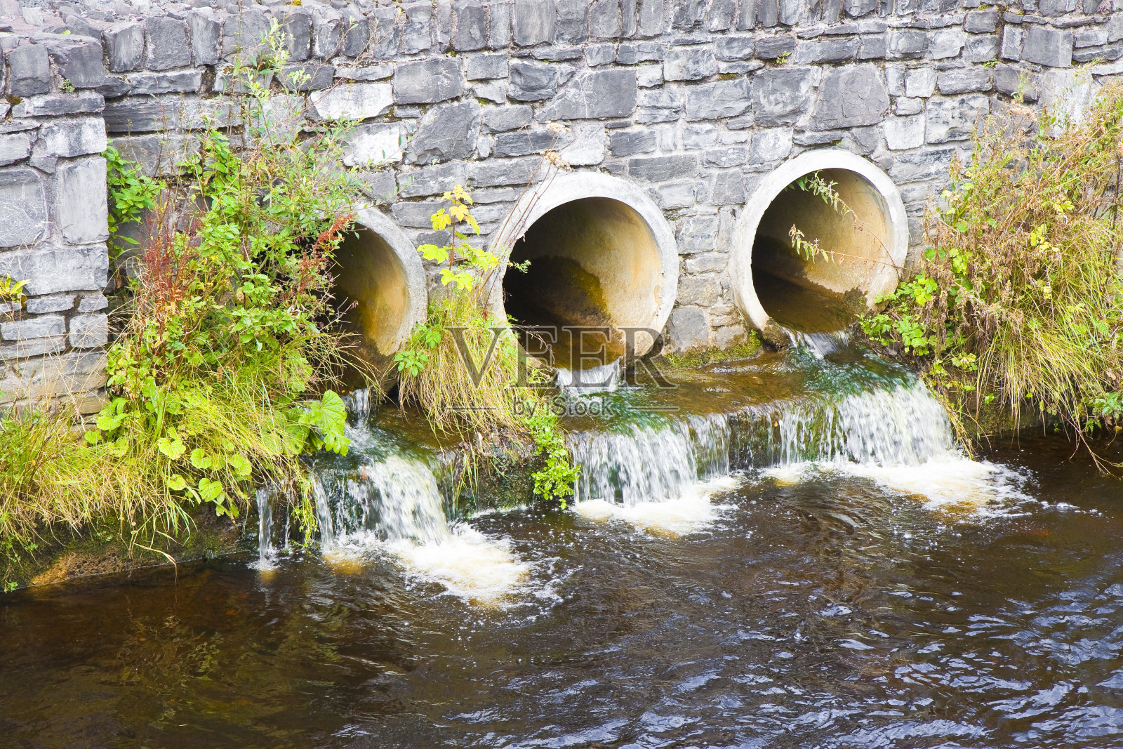 有毒的水通过混凝土排水管流向河流照片摄影图片