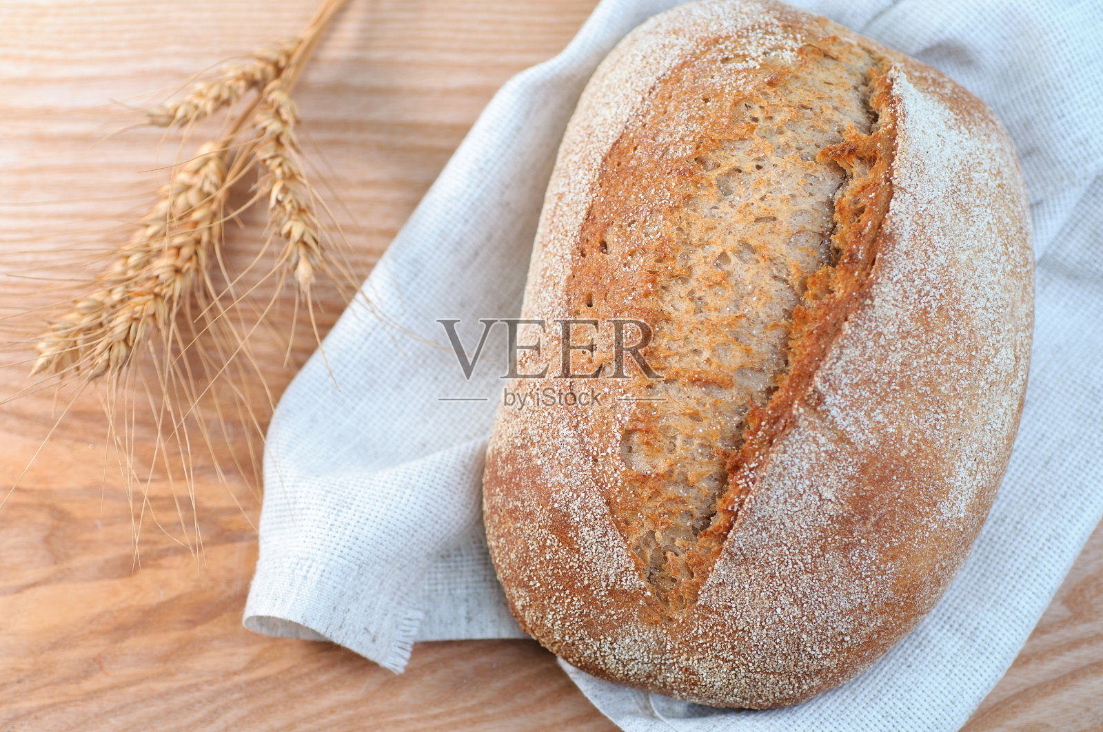 俯视图上的新鲜烤面包在木制的背景，特写照片摄影图片
