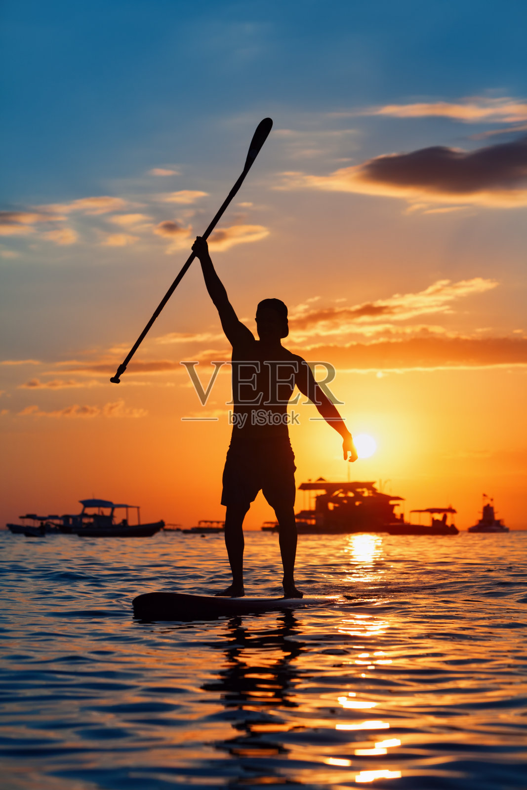 站在SUP上的划桨者的黑色日落剪影照片摄影图片
