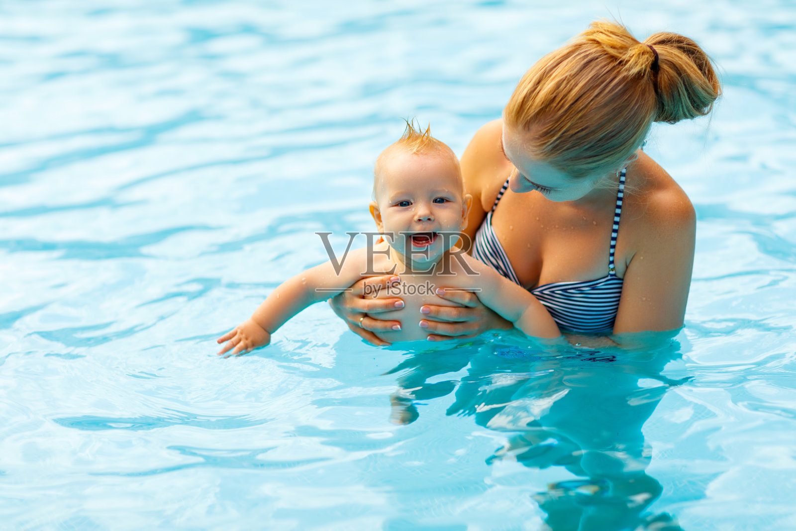妈妈和宝宝在游泳池里游泳照片摄影图片