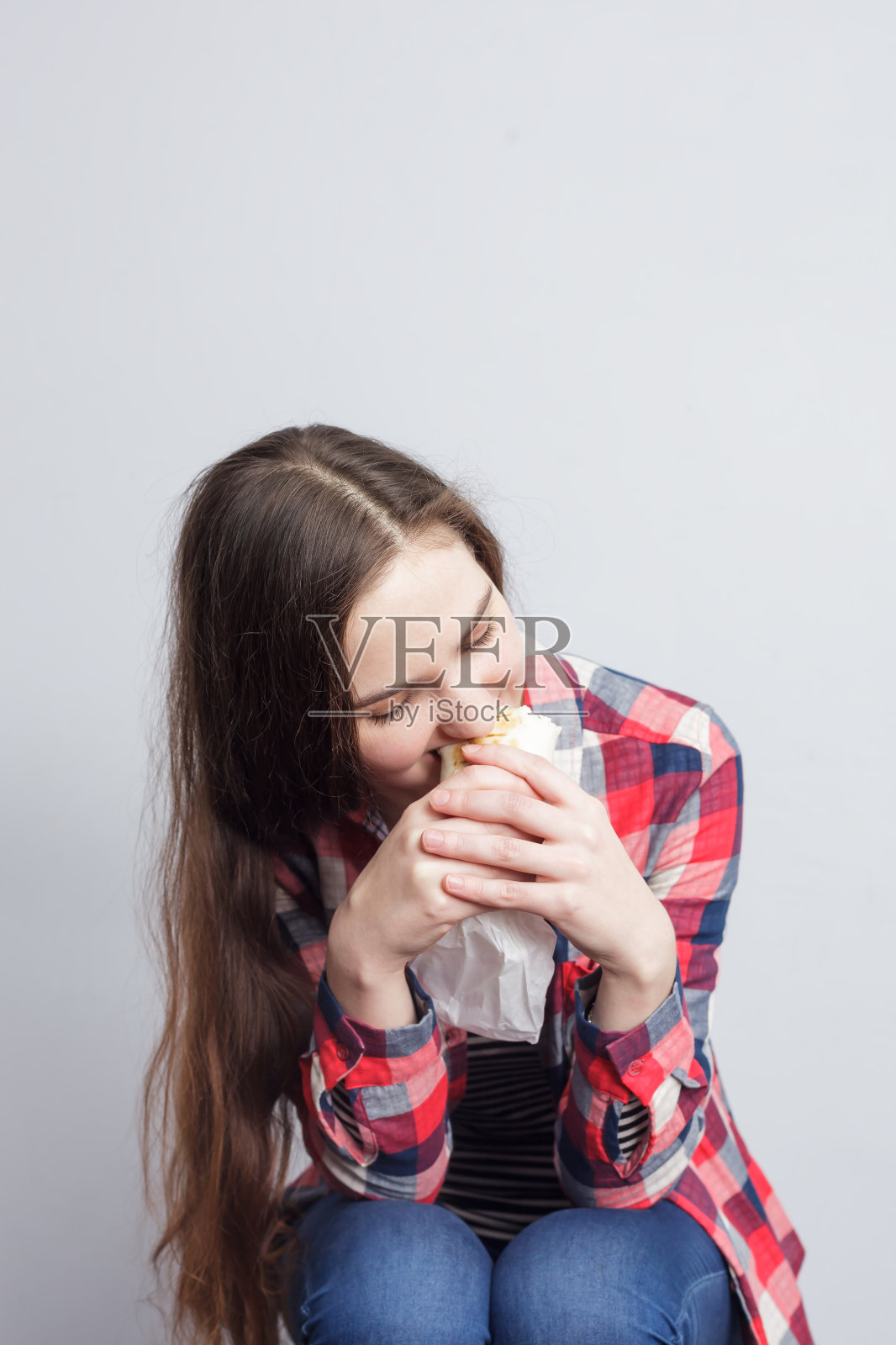 时髦女孩吃新鲜的卷照片摄影图片