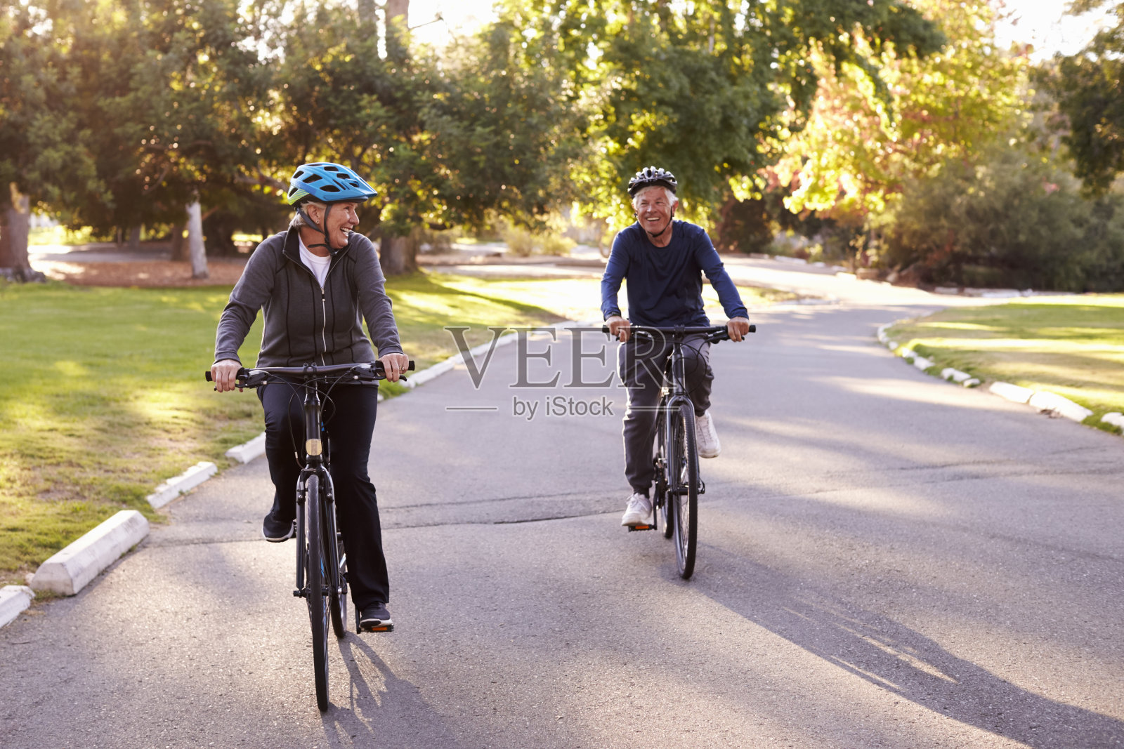 前视图的老夫妇通过公园一起骑车照片摄影图片
