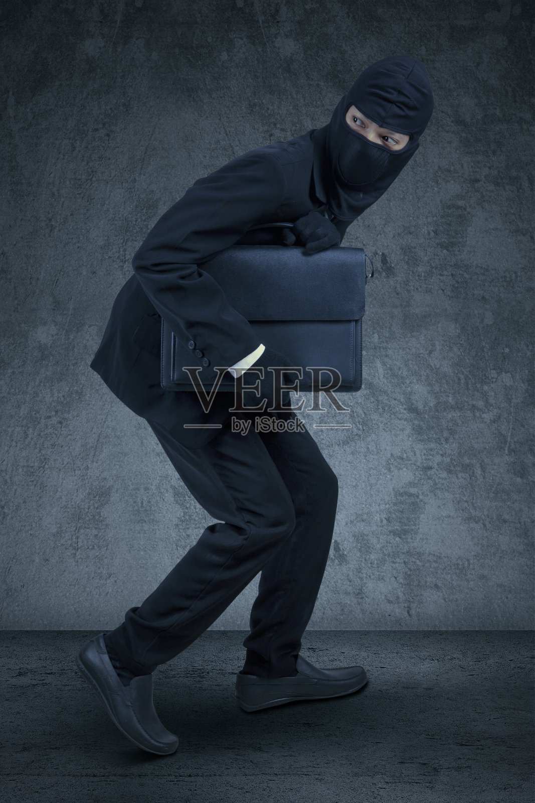 一个戴面具的商人偷了一个公文包照片摄影图片