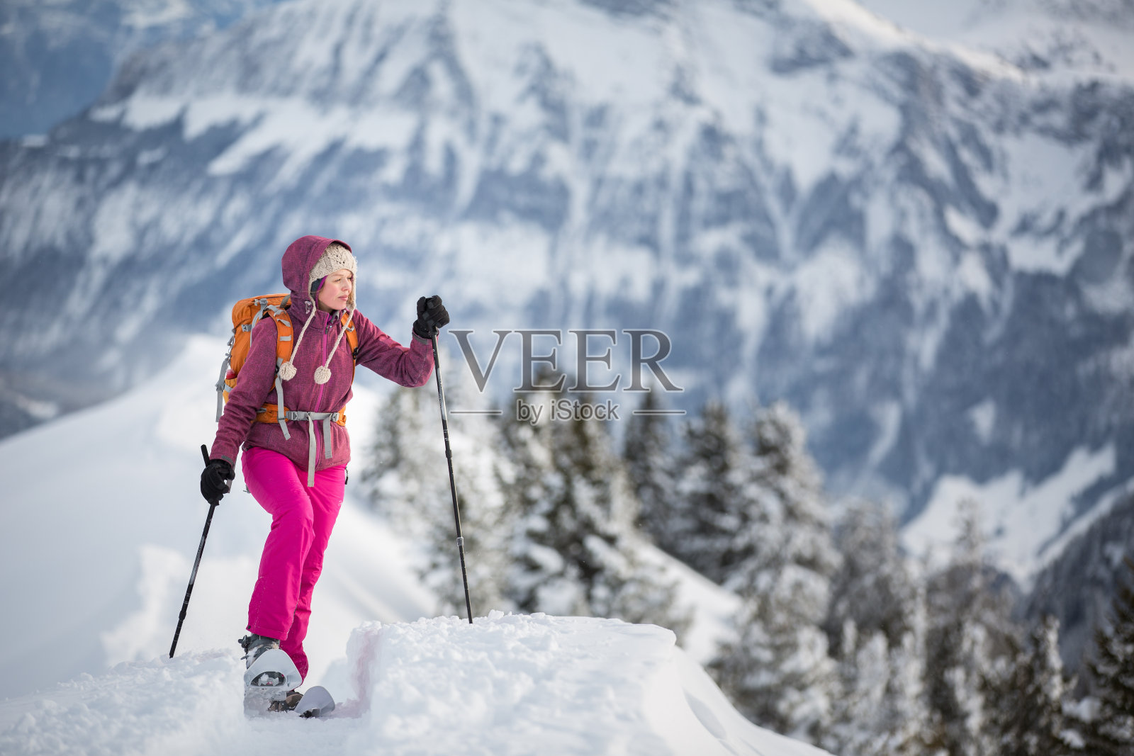 漂亮年轻的女人在高山上穿雪鞋照片摄影图片