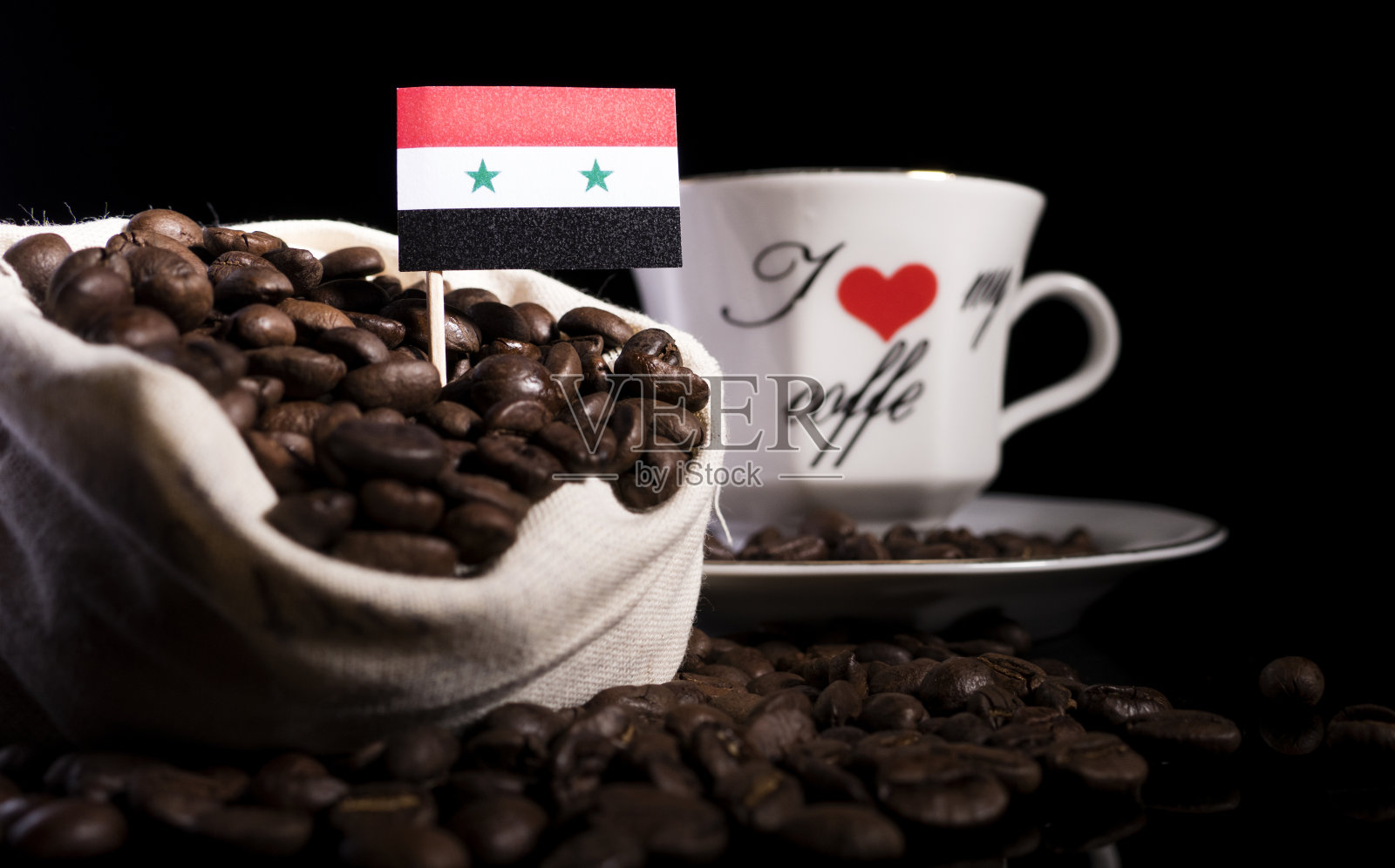 叙利亚国旗装在袋子里，黑色背景上有孤立的咖啡豆照片摄影图片