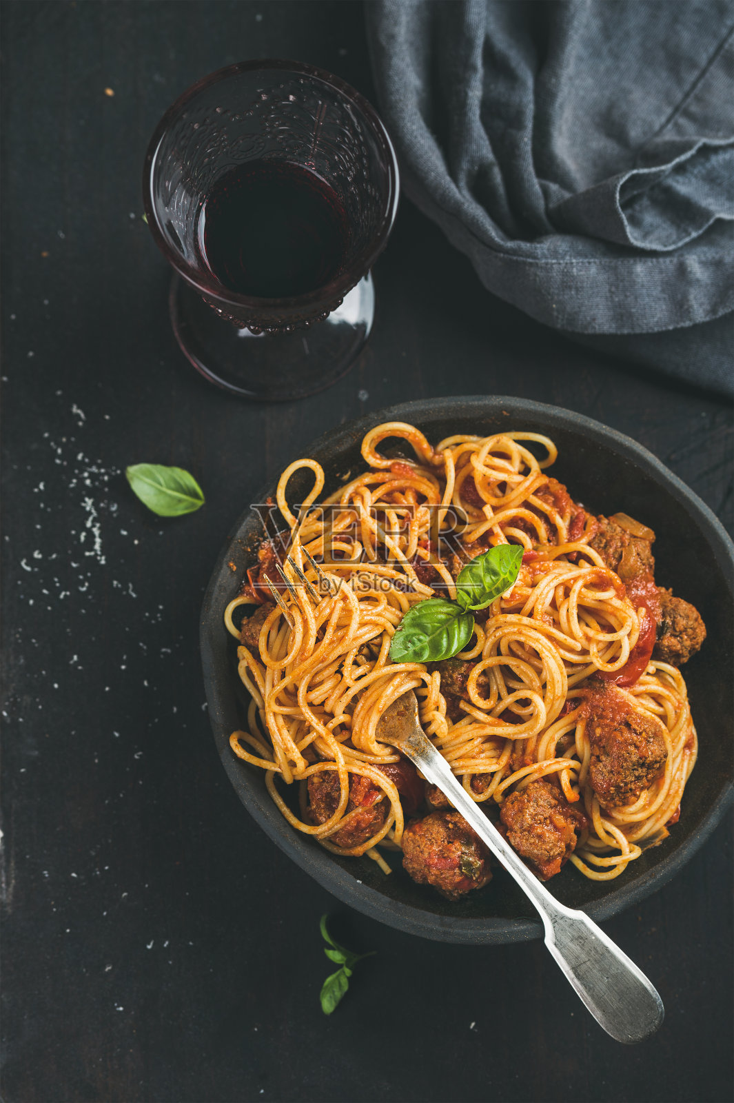 意大利面配肉丸，新鲜的绿色罗勒叶和红酒照片摄影图片