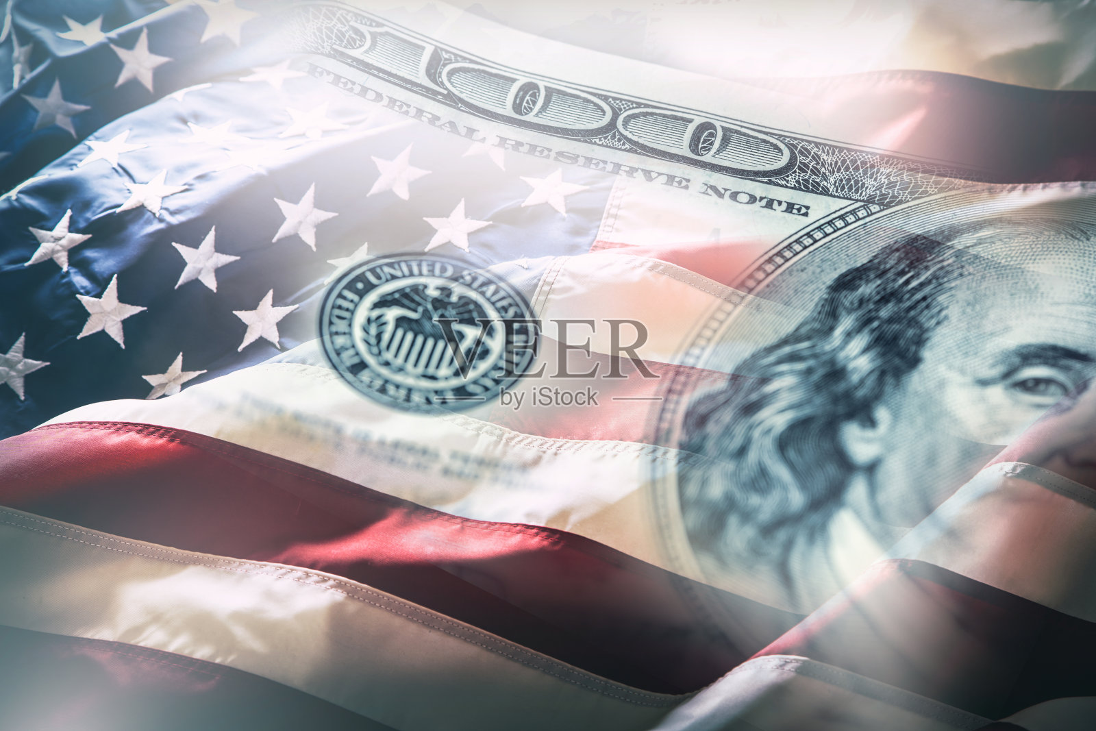 美国国旗和美元。美国国旗在风中飘扬，背景是100美元的钞票照片摄影图片