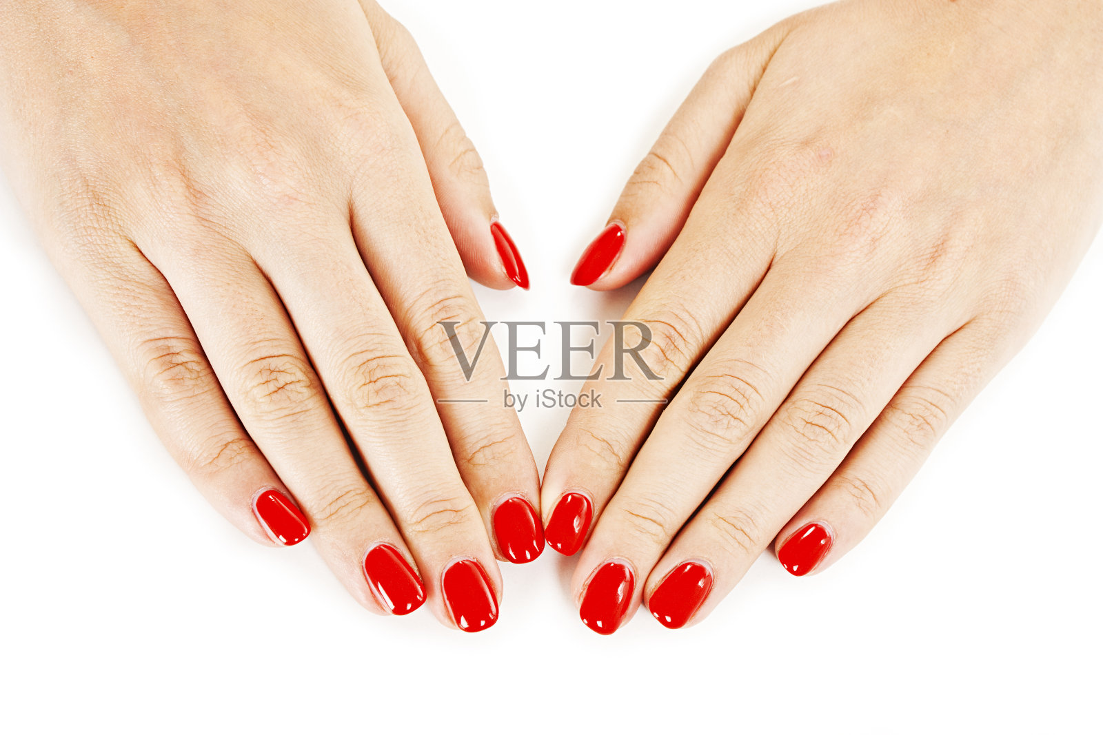 美甲-漂亮的修剪过的女人的手与红色指甲油照片摄影图片