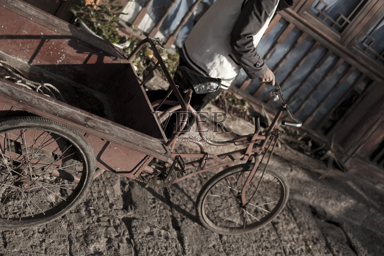 生锈的通勤自行车在中国丽江的鹅卵石街道上行驶照片摄影图片