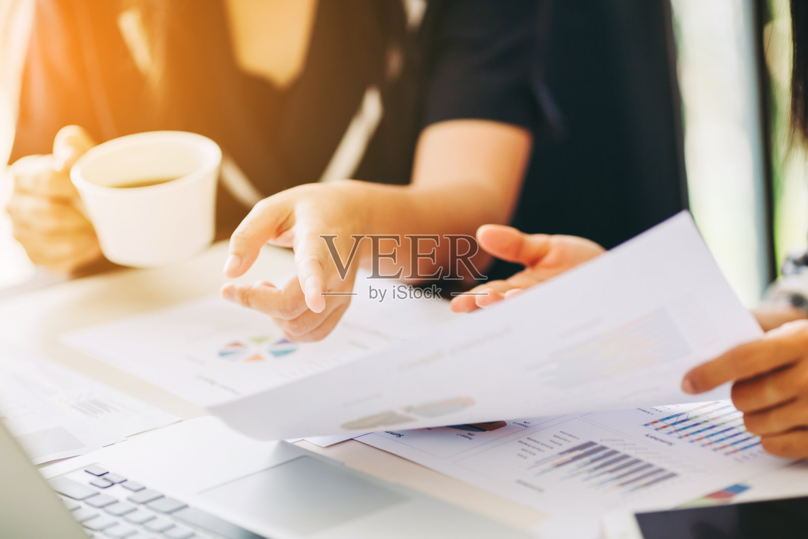 两名商业女性投资顾问分析公司年度财务报告，资产负债表报表与文件图表。照片摄影图片