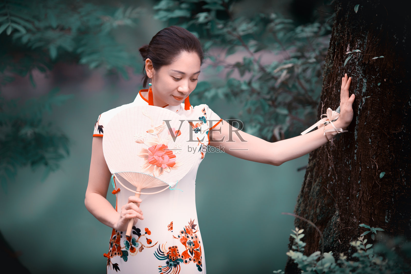 美丽的中国女子站在绿植茂盛的河岸上照片摄影图片