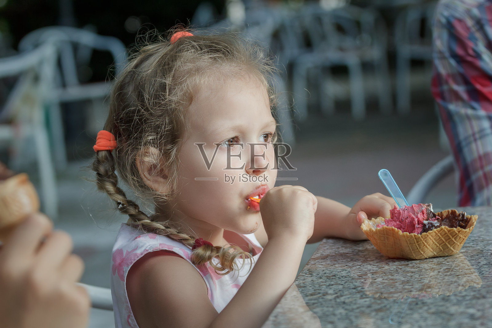 可爱的女孩在吃她的意大利威化冰淇淋蛋卷照片摄影图片