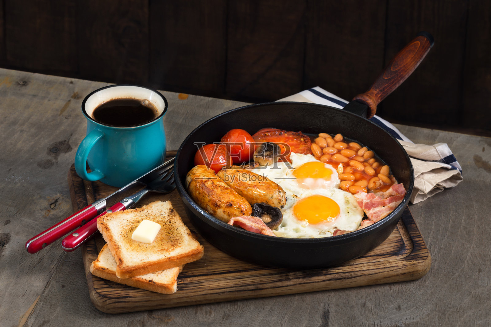 英式早餐有香肠，培根，煎蛋，豆子，吐司和咖啡放在木桌上照片摄影图片