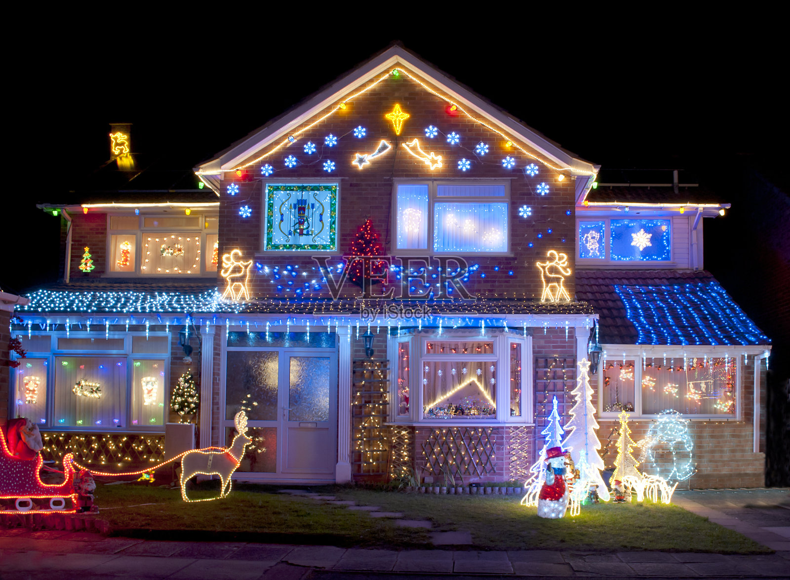 房子被明亮的圣诞灯装饰得五彩缤纷照片摄影图片
