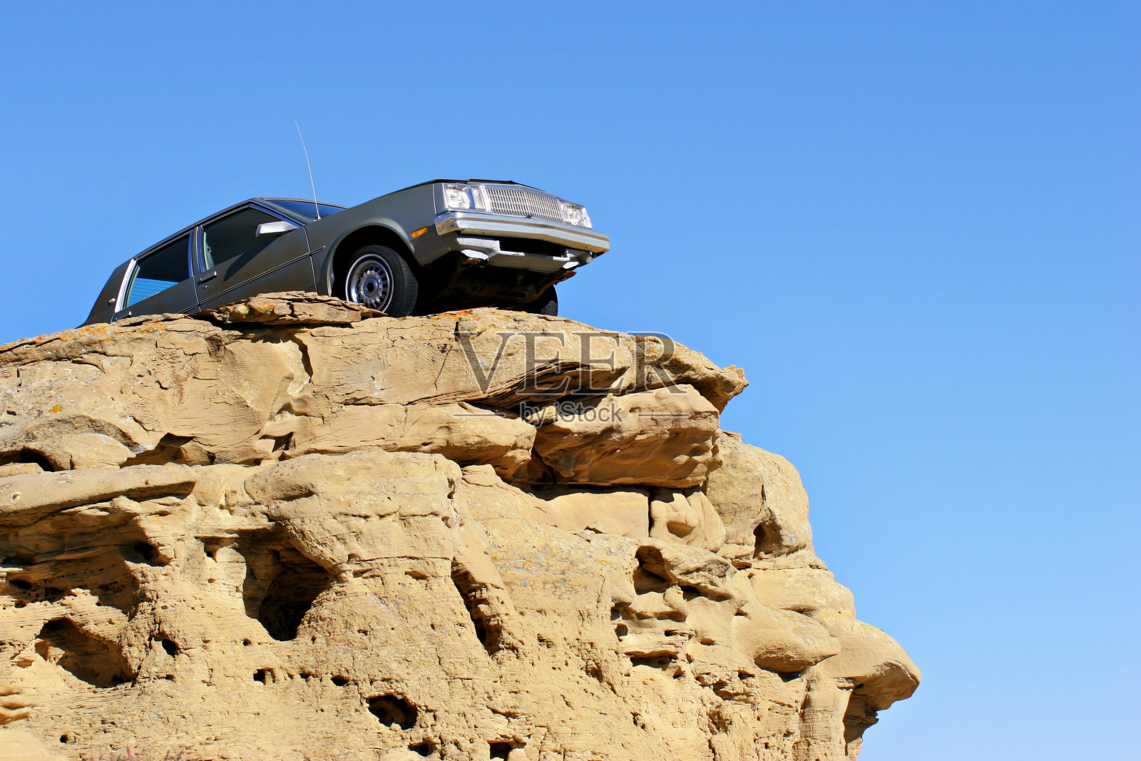 一辆汽车摇摇欲坠地停在岩石上照片摄影图片