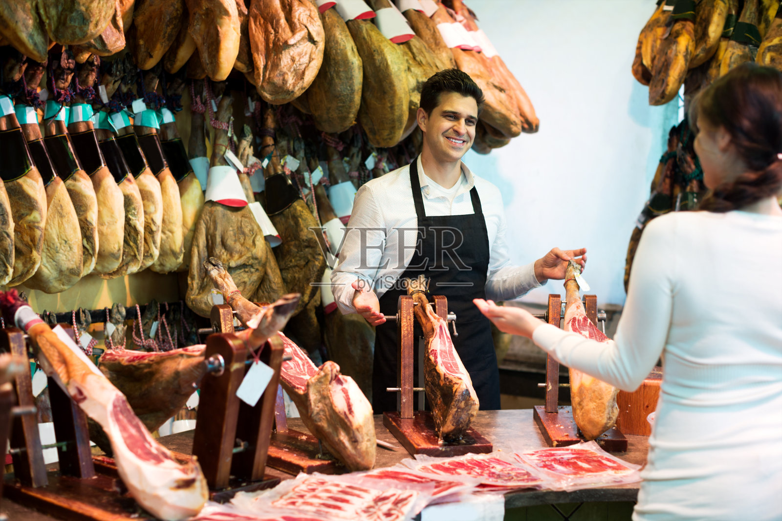 女顾客正在购买西班牙火腿照片摄影图片