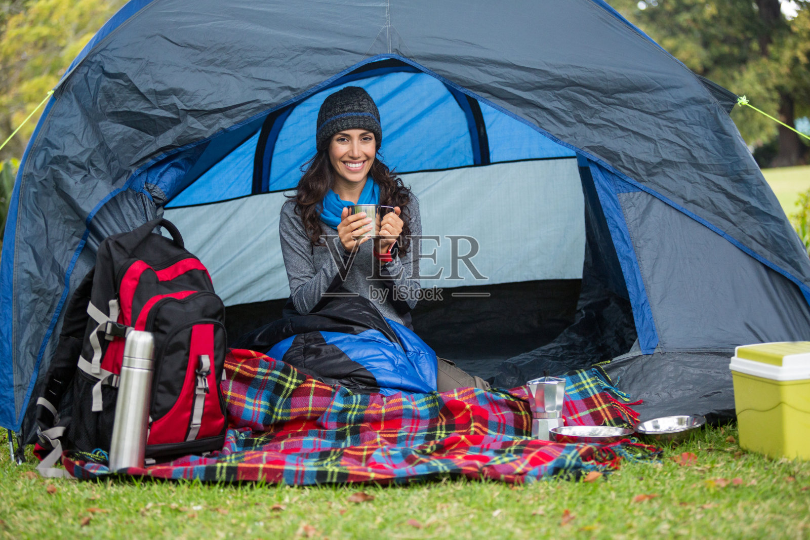 微笑的徒步旅行者在帐篷里喝咖啡的肖像照片摄影图片