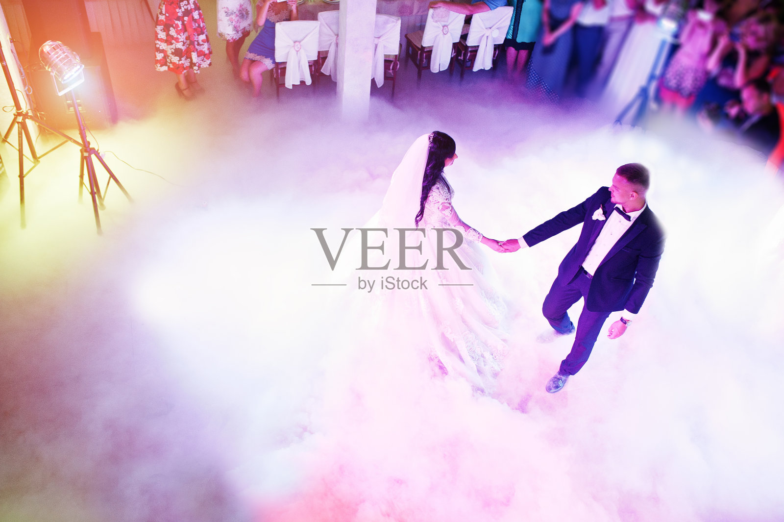 令人惊奇的新婚舞蹈与不同色彩的轻和重的烟在餐厅。照片摄影图片