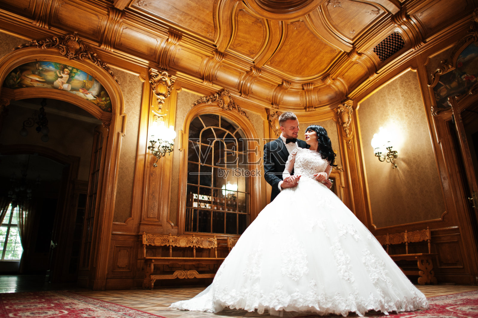 令人敬畏的婚礼夫妇室内丰富的皇家房间与经典的木制设计照片摄影图片