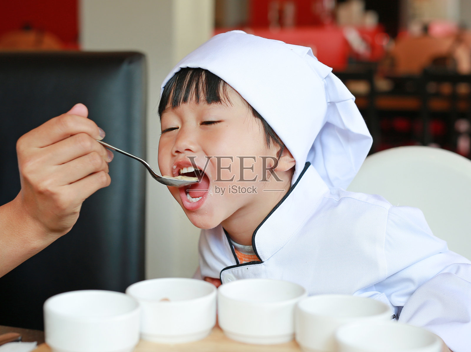 小酋长正在学吃美味的食物。照片摄影图片