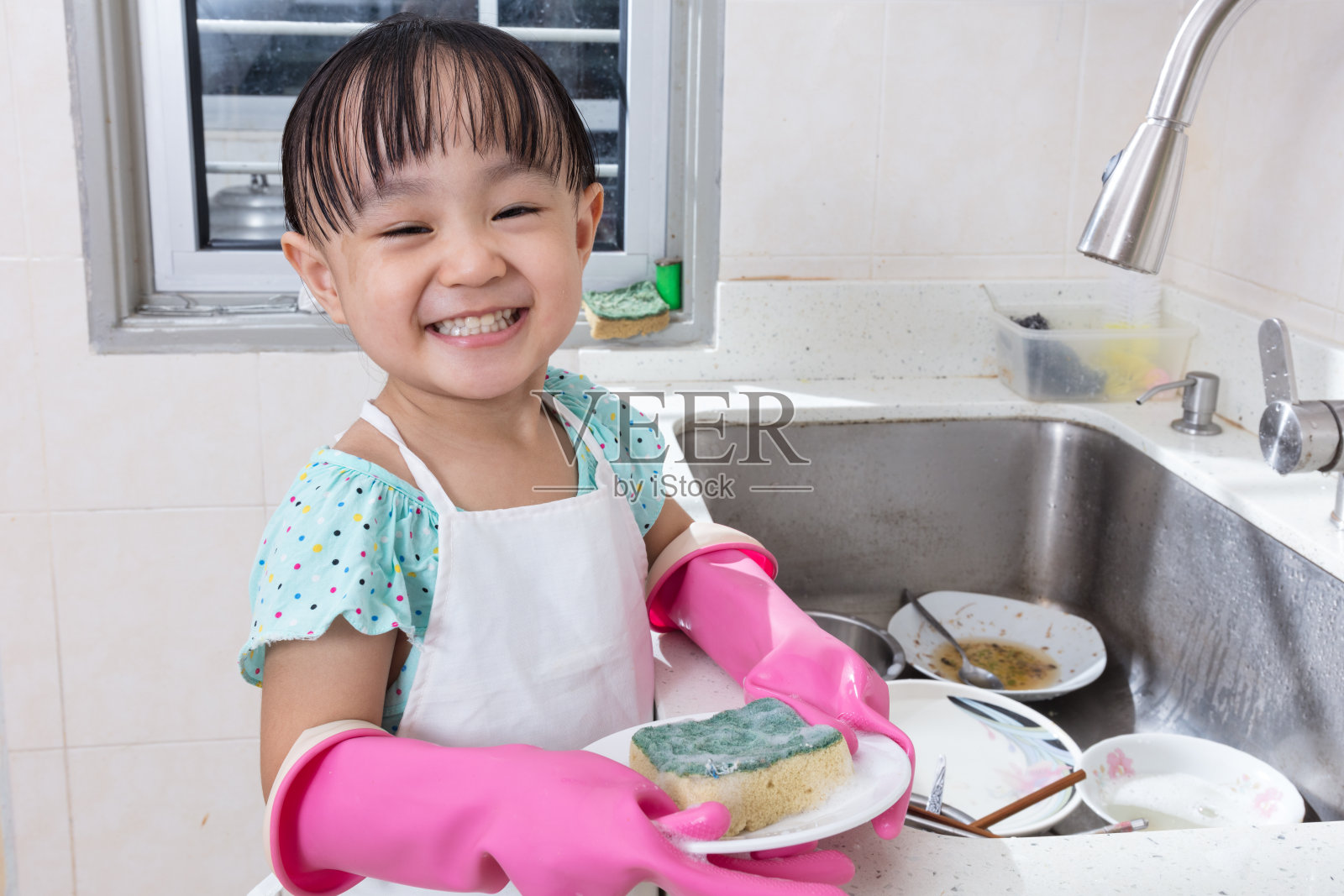 亚洲华人小女孩在厨房洗盘子照片摄影图片