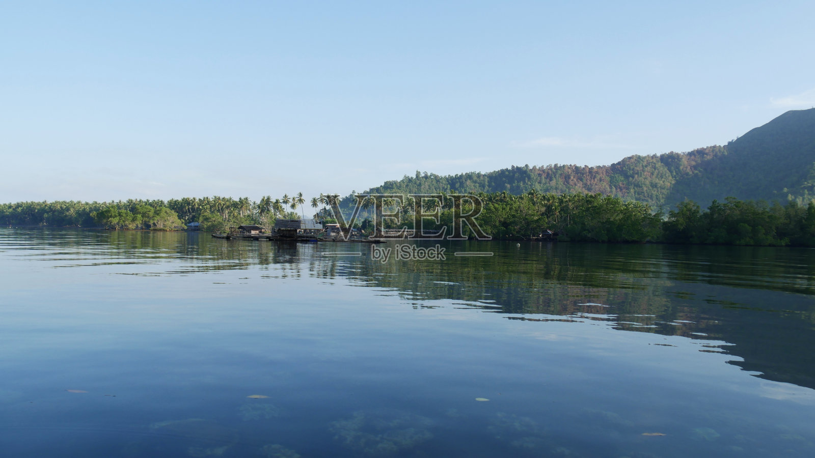 宁静的水面映照着一个渔村照片摄影图片