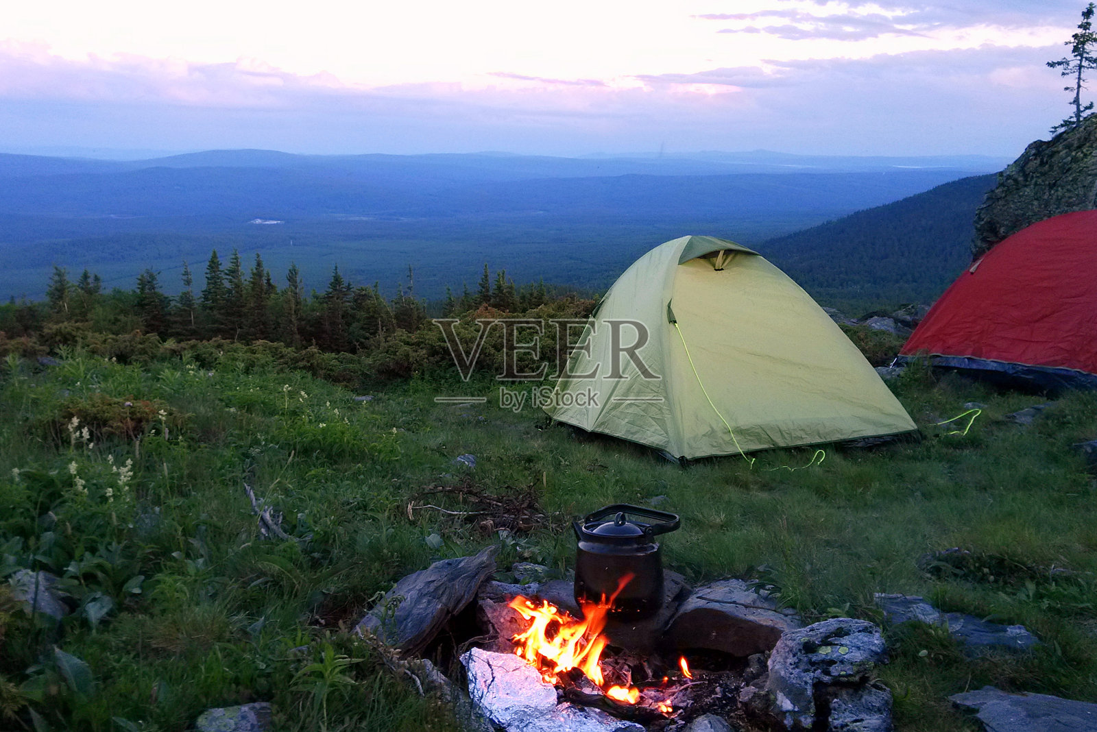 去俄罗斯的乌拉尔山脉旅行。有帐篷和篝火的露营。照片摄影图片
