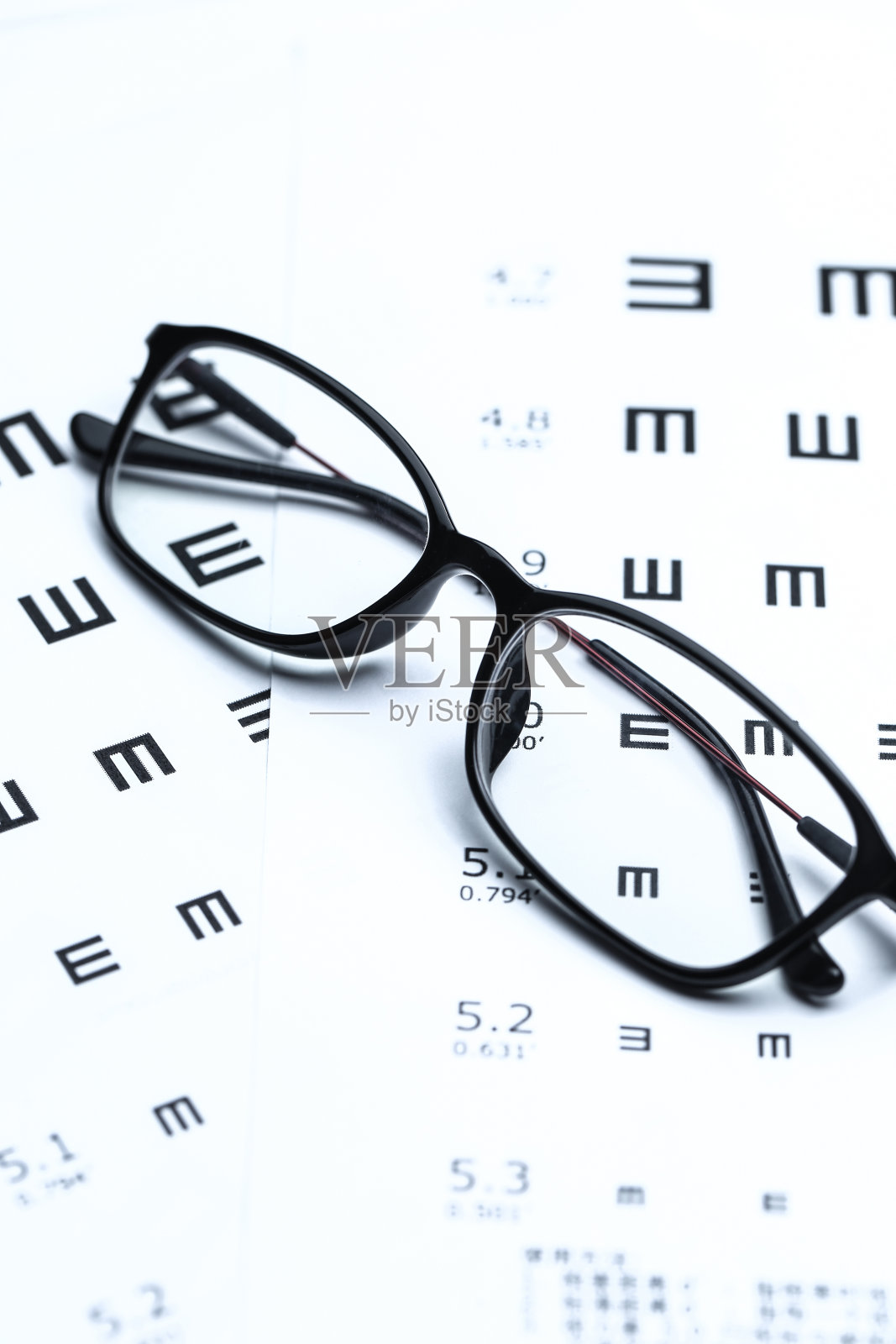 白色背景上的眼镜和视力表照片摄影图片