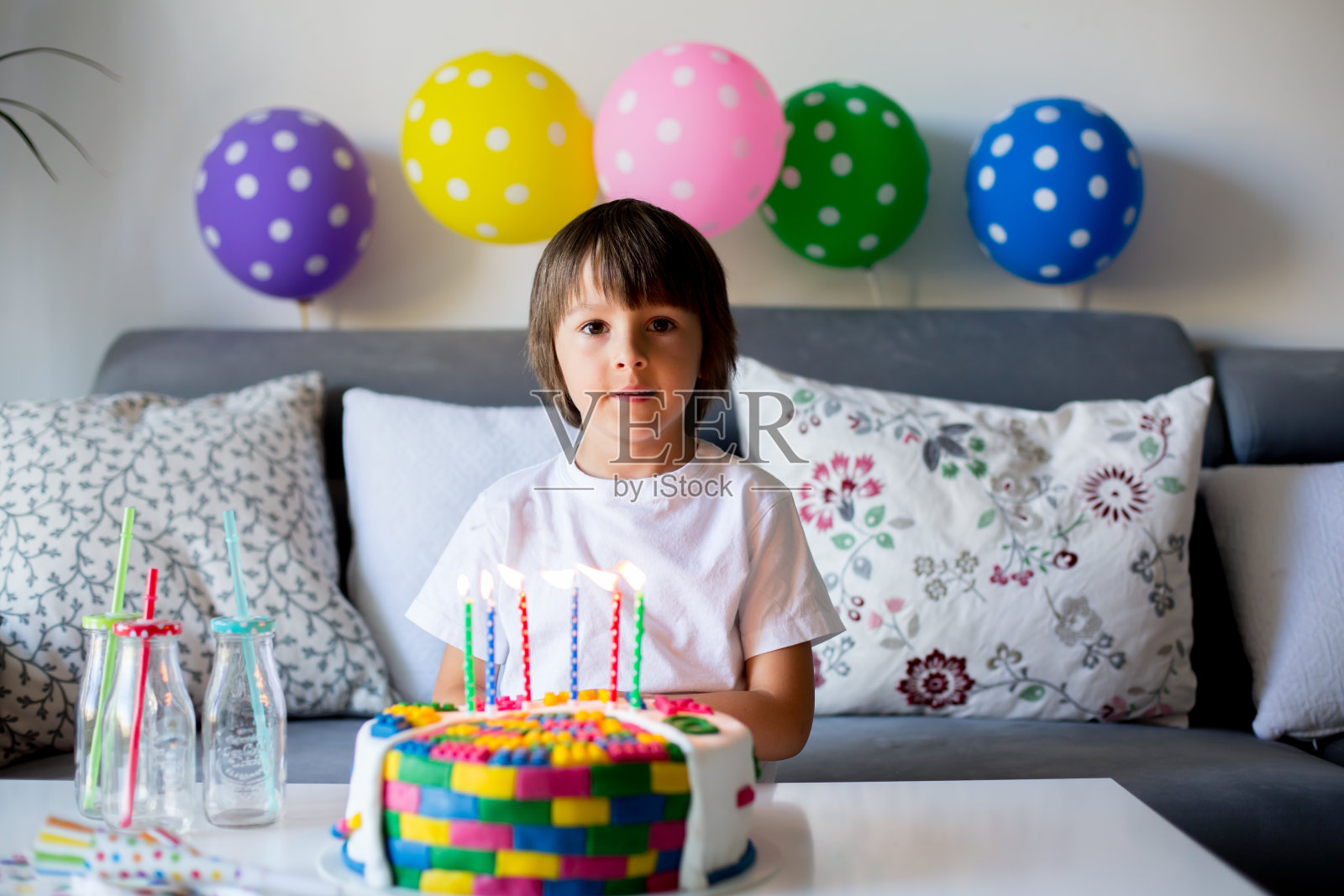 可爱的小男孩，庆祝他的六岁生日，蛋糕，气球，蜡烛，饼干。童年幸福的概念照片摄影图片