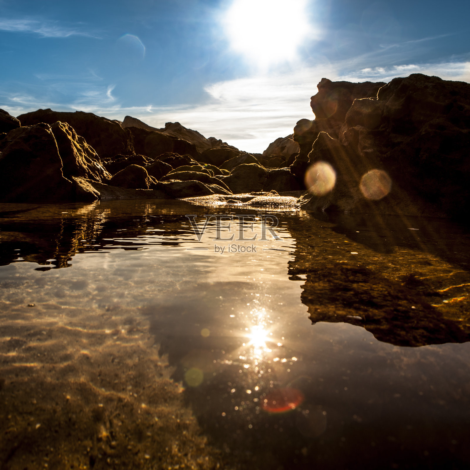 明亮的太阳照耀着岩石和大海照片摄影图片