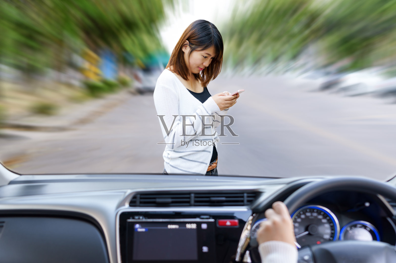 女人开车又快又危险。女人在路上使用智能手机会被车撞。照片摄影图片