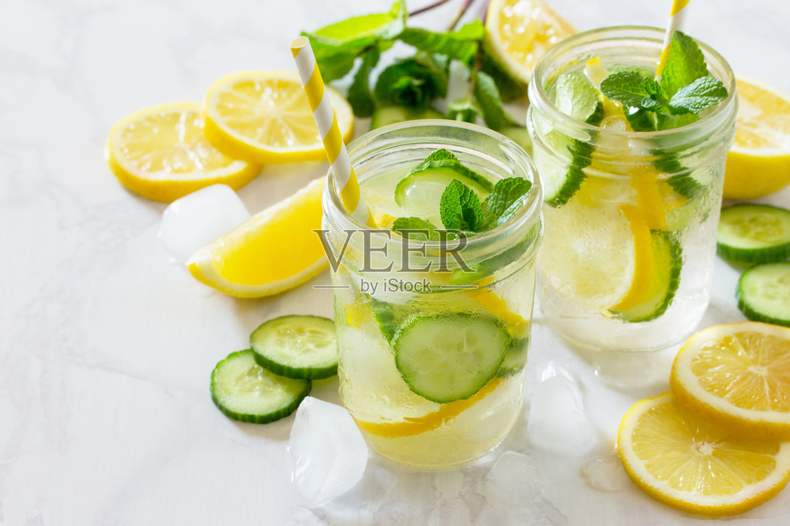 清新的夏日饮品，柠檬和黄瓜在石头的背景。吃素食的概念，新鲜的维生素，自制清爽的水果饮料。照片摄影图片