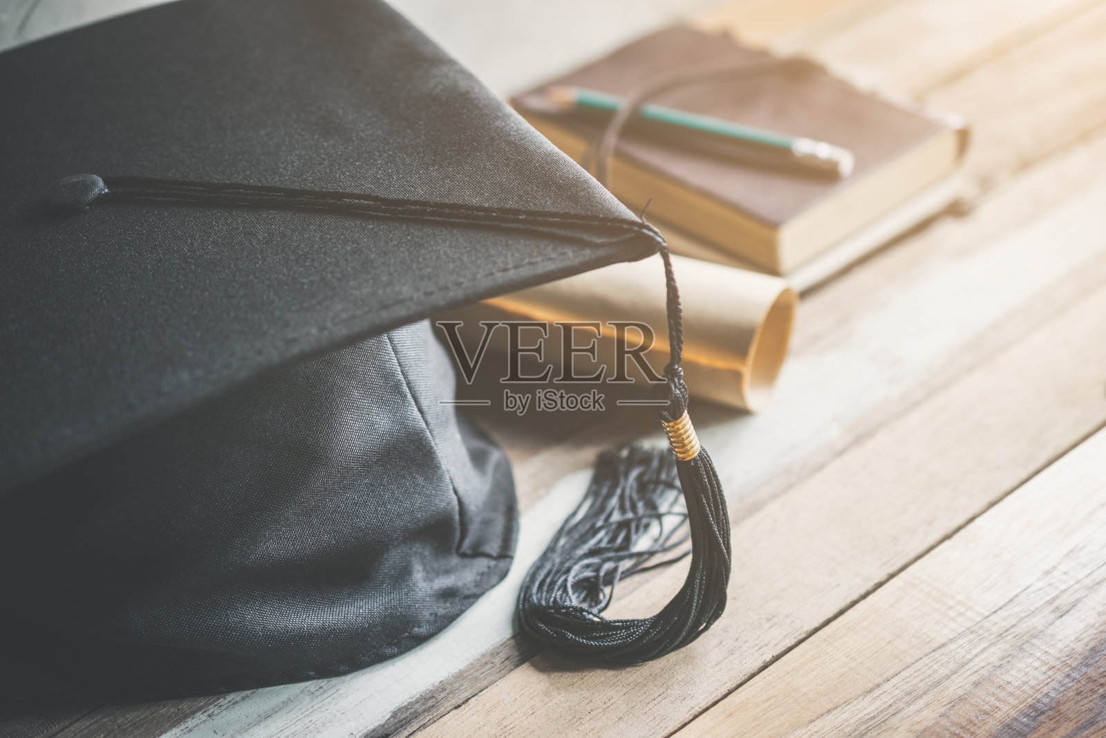毕业帽，带学位帽的木桌上有毕业概念。照片摄影图片