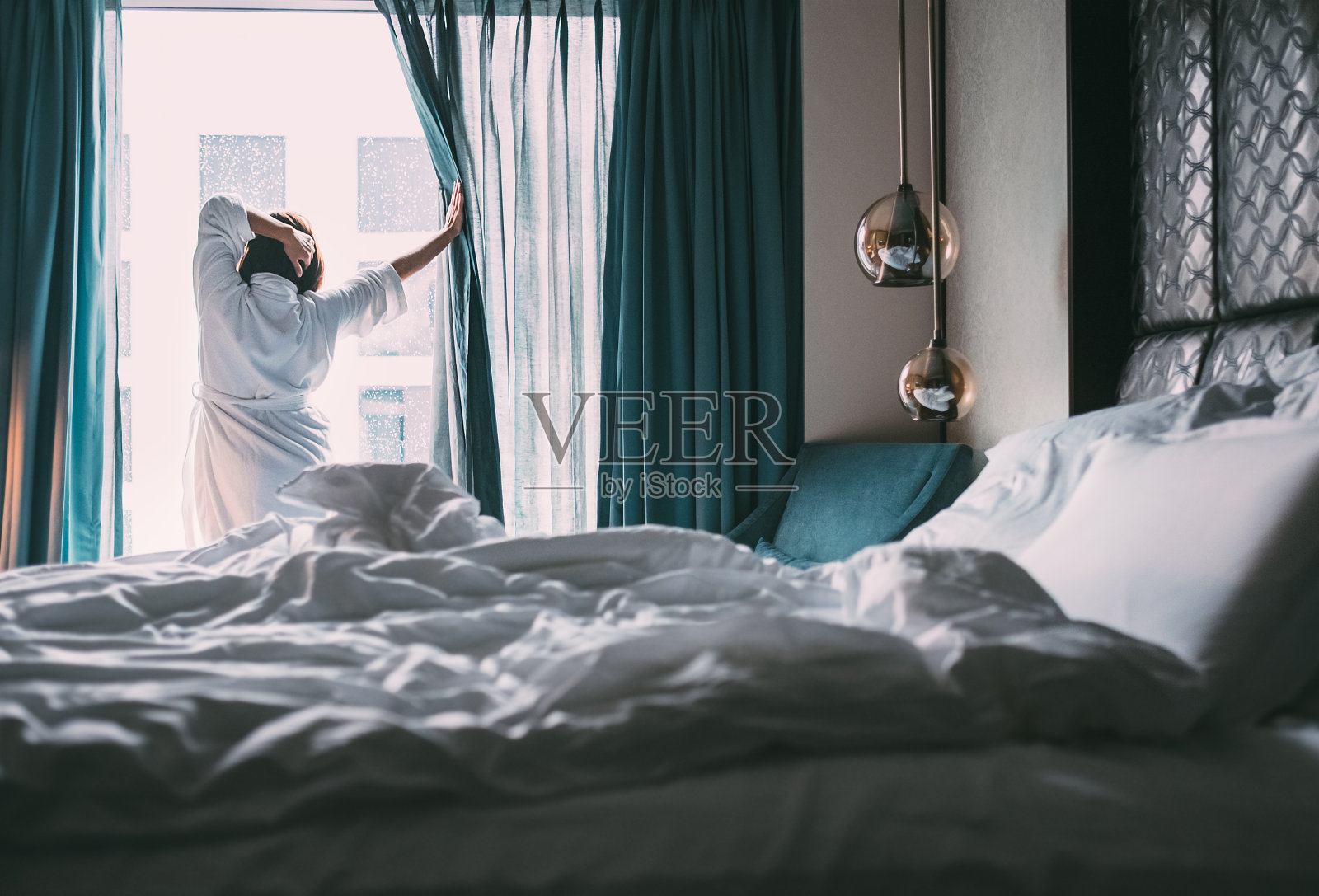 女人遇到下雨的早晨在豪华酒店房间照片摄影图片