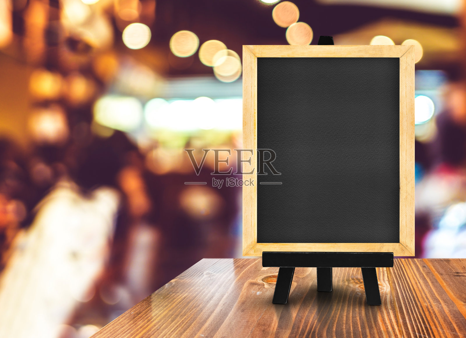 模糊的咖啡店背景木桌上的带有画架的黑板，模拟展示或蒙太奇设计用于网上购物促销照片摄影图片