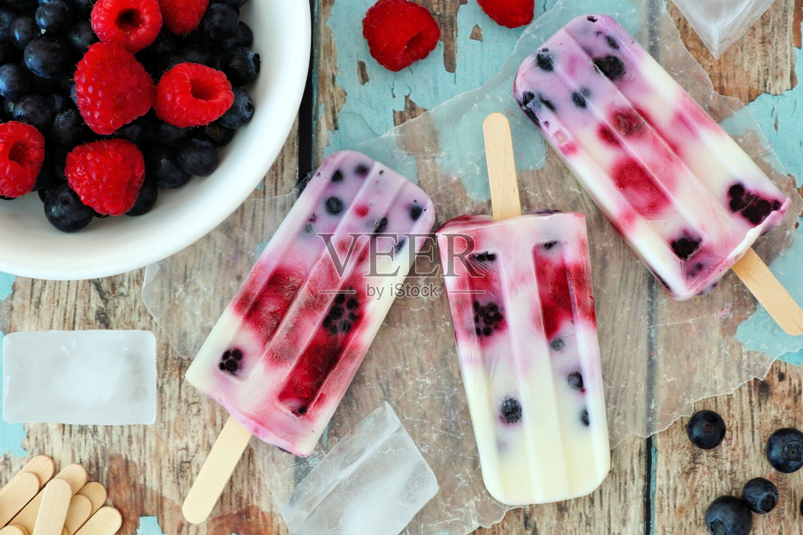 混合浆果酸奶冰棒在一个乡村的木材背景照片摄影图片